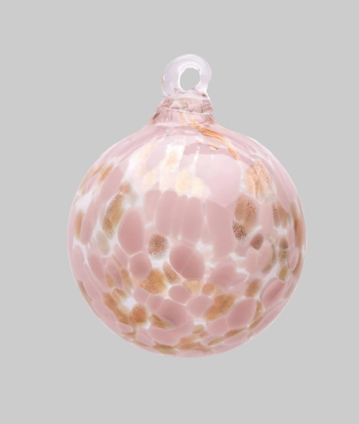 A round glass Christmas ornament with a pale pink base, decorated with organic-shaped lighter pink and tan inclusions, and a clear glass hanging loop at the top, shown on a plain white background.