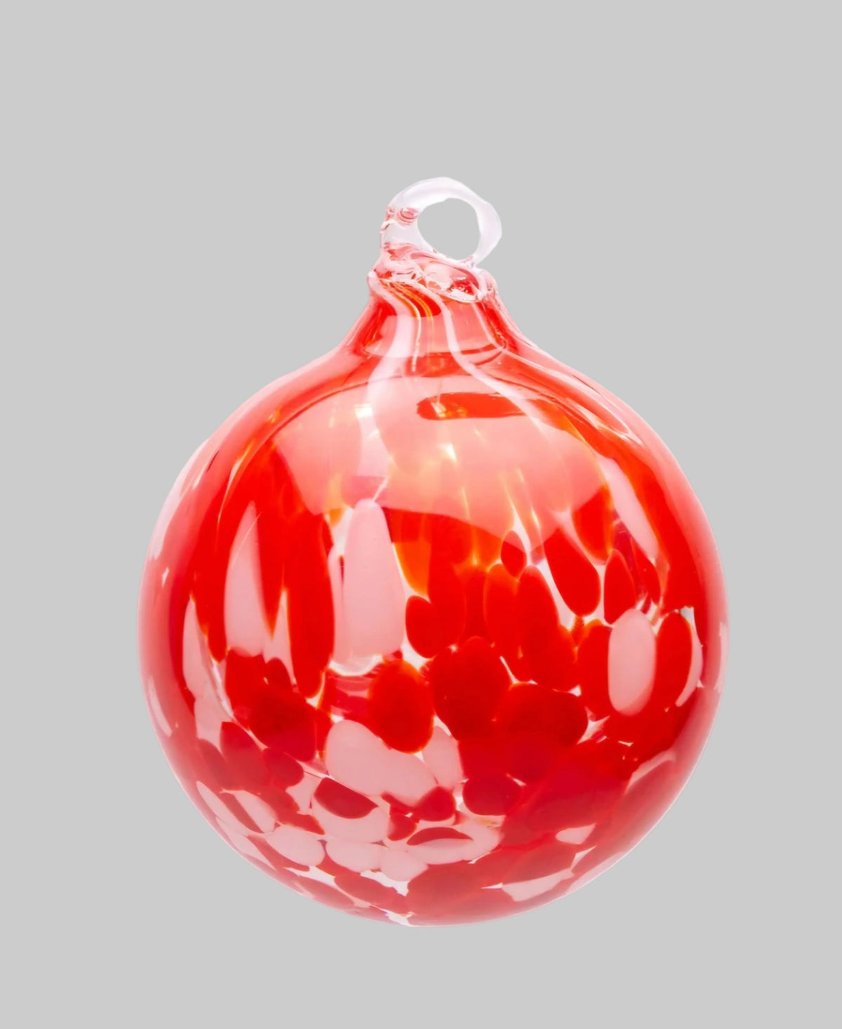 A red glass Christmas ornament with a hanging loop, featuring a swirled, marbled pattern of lighter red and white highlights, isolated on a white background.