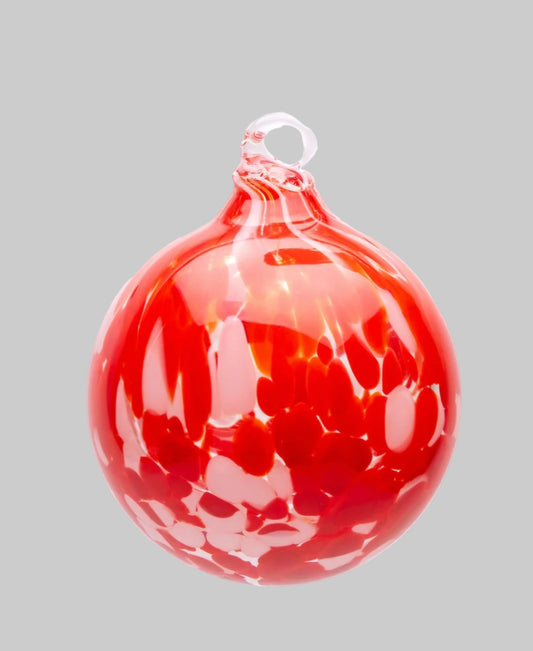A red glass Christmas ornament with a hanging loop, featuring a swirled, marbled pattern of lighter red and white highlights, isolated on a white background.